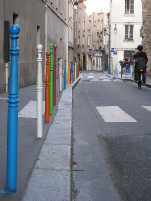 Festive pedestrian posts in Saint-Paul. The stonework at right is one of the last remnants of the 12th century city wall of Philippe-Auguste.