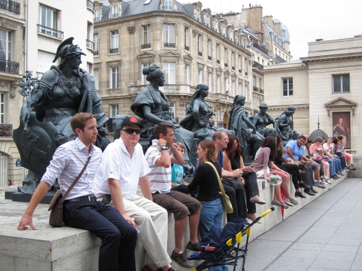 Tourists unconsciously echoing statues on the plaza of the Musee d'Orsay.